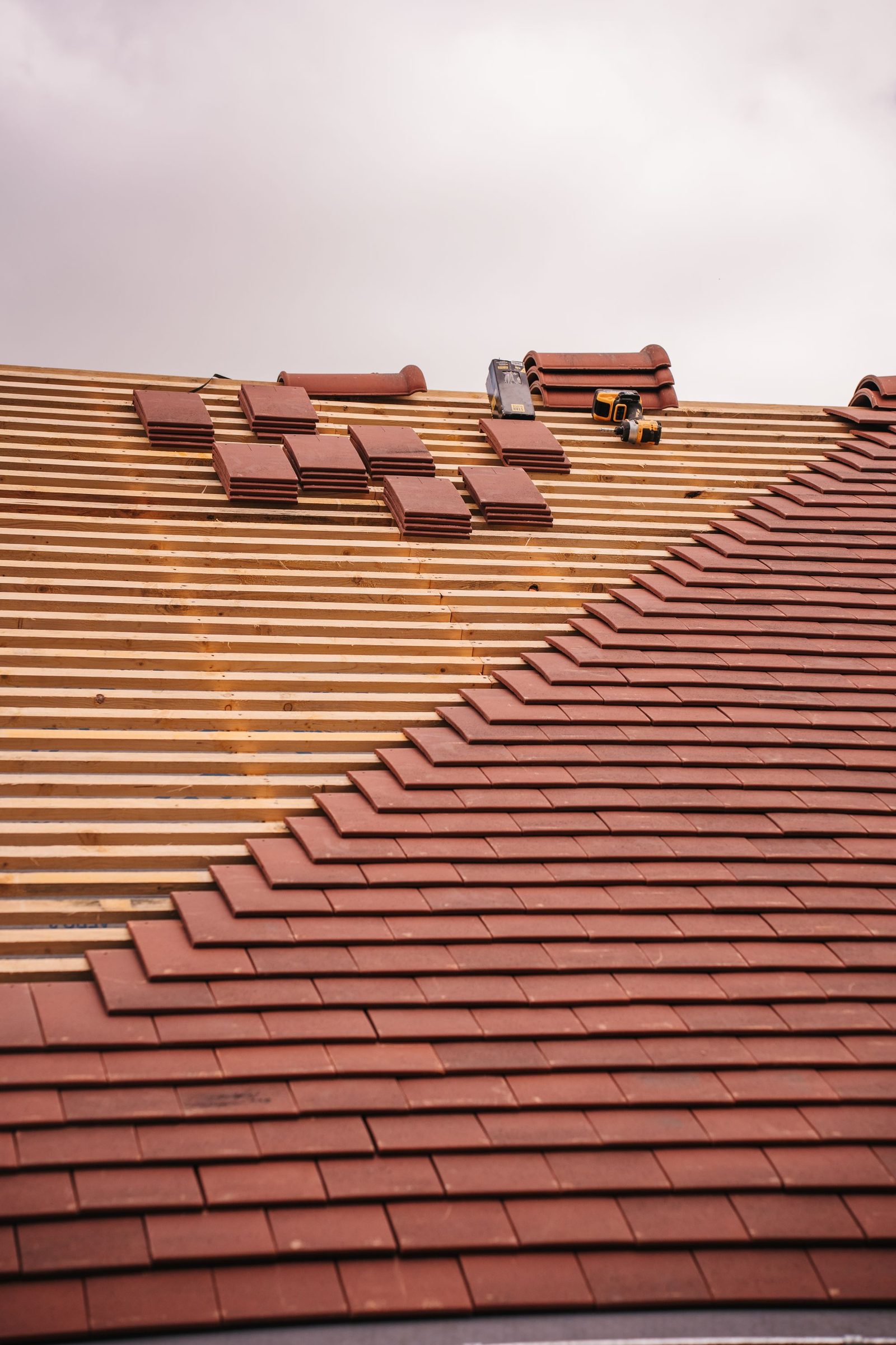 New tiled roof being fitted with courses of tiles in progress